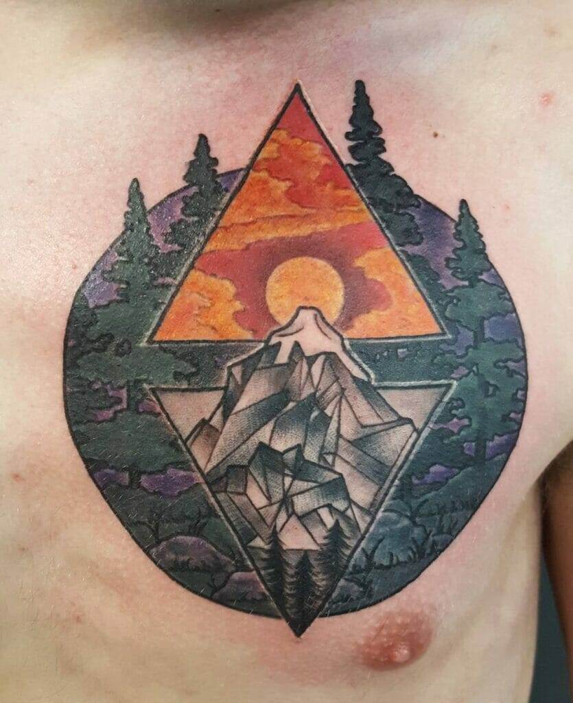 A tattoo featuring a geometric design with a mountain and trees under an orange sky with the sun, placed on the left side of a person's chest.