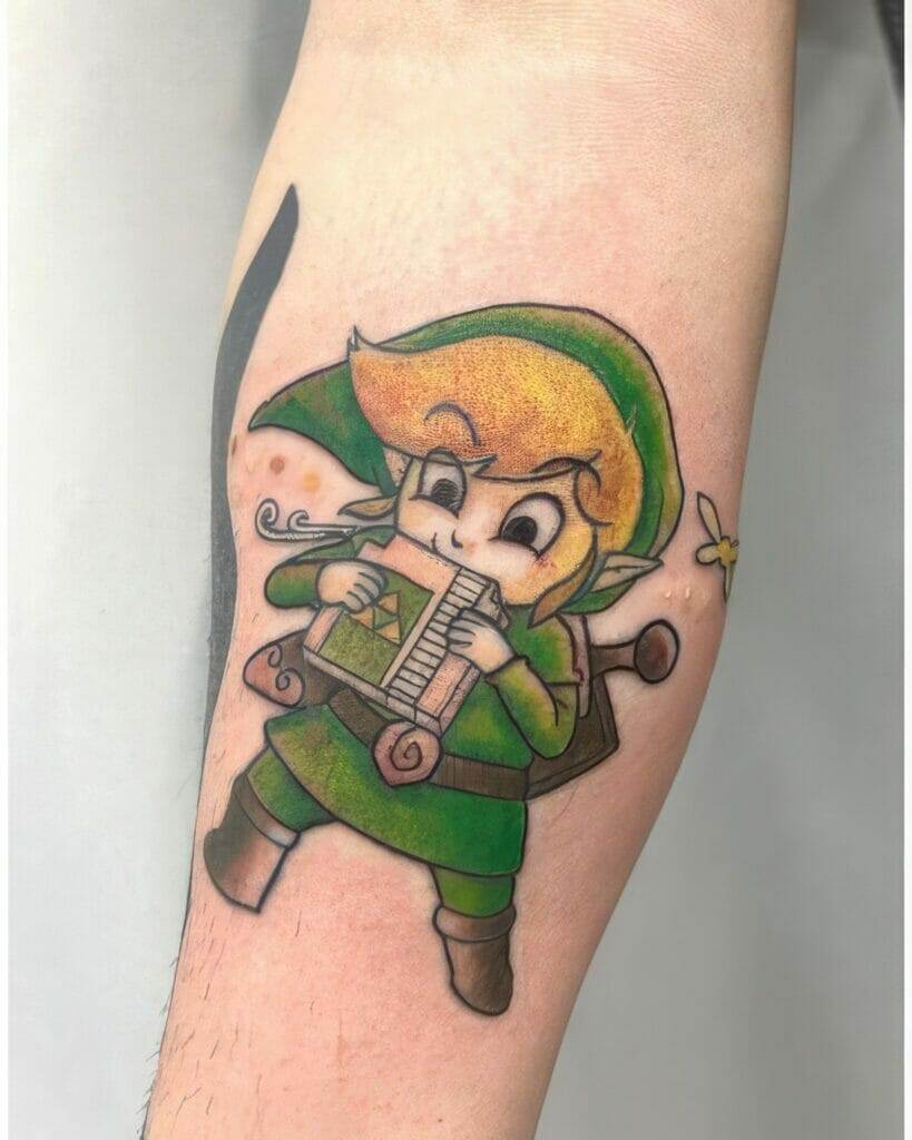 A colorful tattoo of a cartoon character in green attire playing a small pan flute is on a person's forearm.