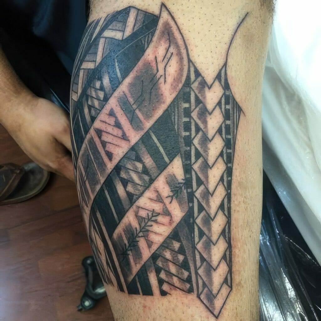 A close-up image of a leg tattoo featuring intricate geometric and woven patterns with a mix of black and shaded designs.
