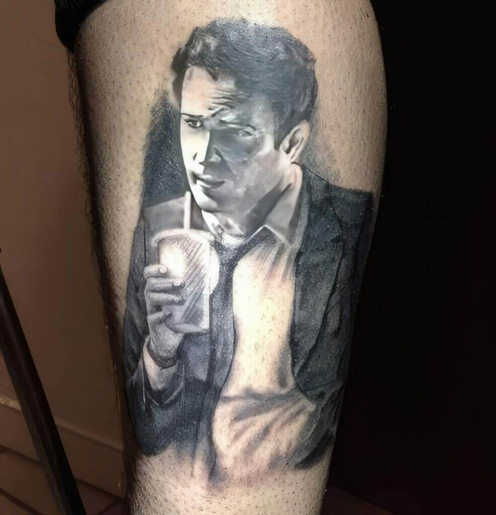 A black and gray tattoo on an individual's skin depicts a portrait of a man in a suit holding a cup.