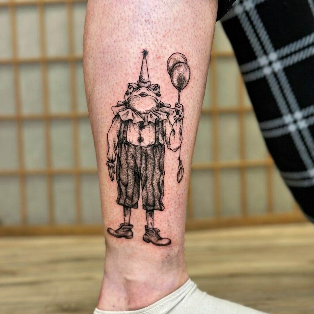 A tattoo of a frog dressed in clown attire holding a balloon is displayed on a person's leg.