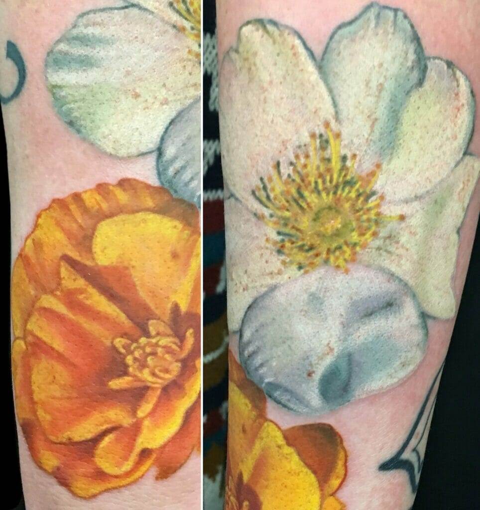 Close-up image of a floral tattoo featuring yellow and white flowers with detailed petals and centers on a person's skin.