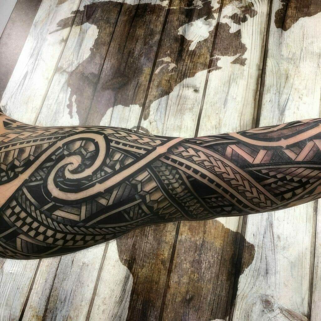 A forearm with a detailed black geometric tattoo design sits over a wooden surface with a world map pattern.