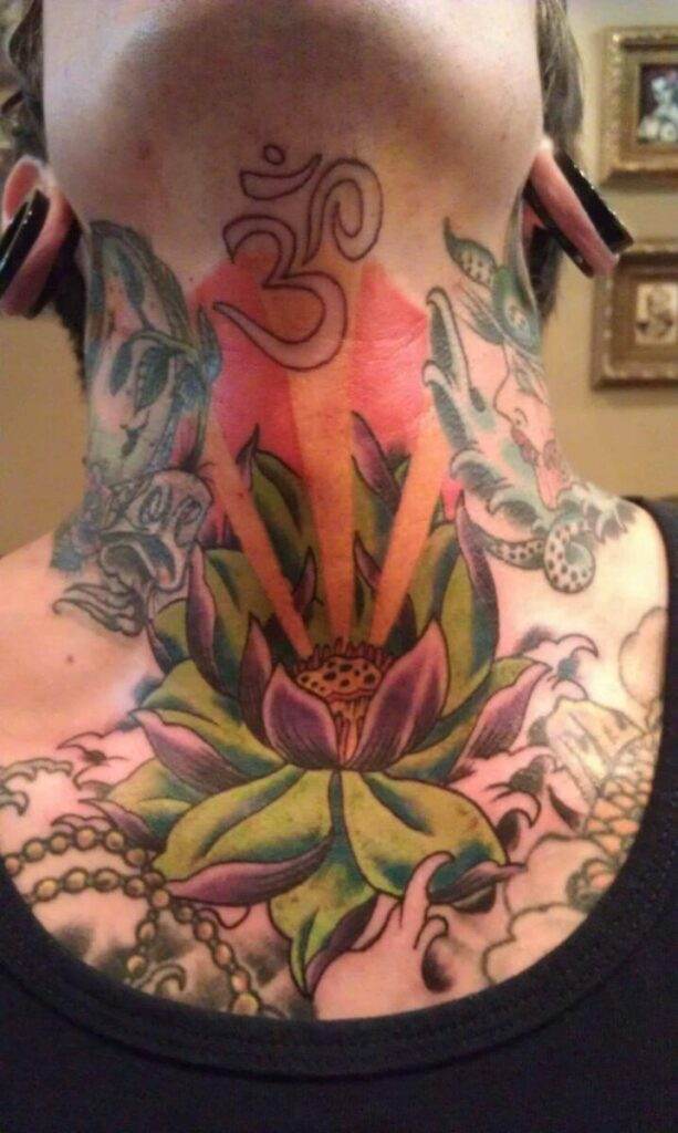An image of a person's neck with detailed tattoos, including an 'Om' symbol, a lotus flower, rays of light, two grayish creatures on the sides, and various other intricate designs.