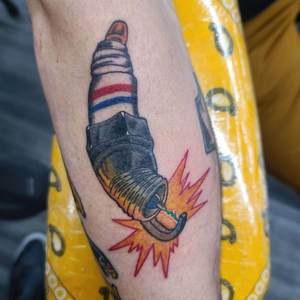 A tattoo of a spark plug with a barber pole stripe and an explosive burst of light at the base, situated on someone's forearm.