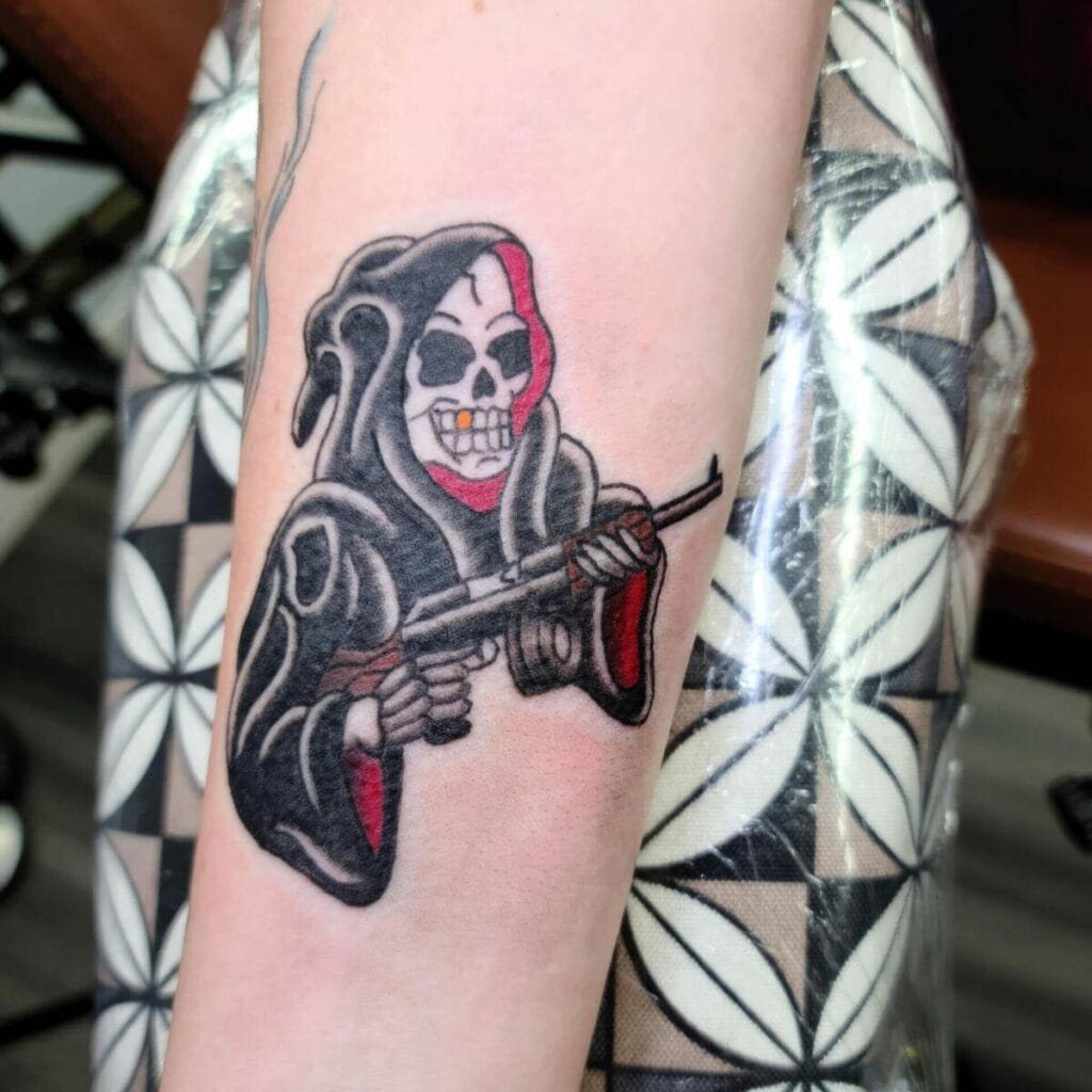 Forearm tattoo of a grim reaper wearing a black hood and holding a weapon, with a red highlight on the hood, against a faint patterned background.