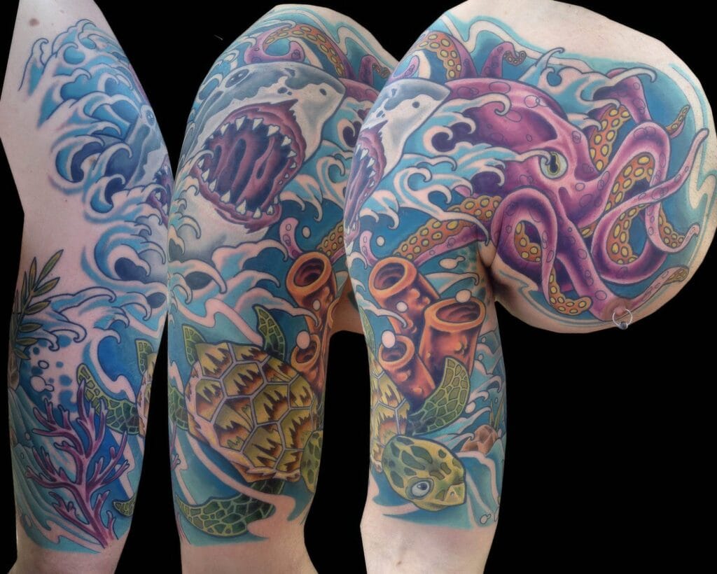 Colorful tattoo sleeve depicting a sea-themed scene with a turtle, octopus, shark, fish, and coral set against ocean waves on a person's arm.