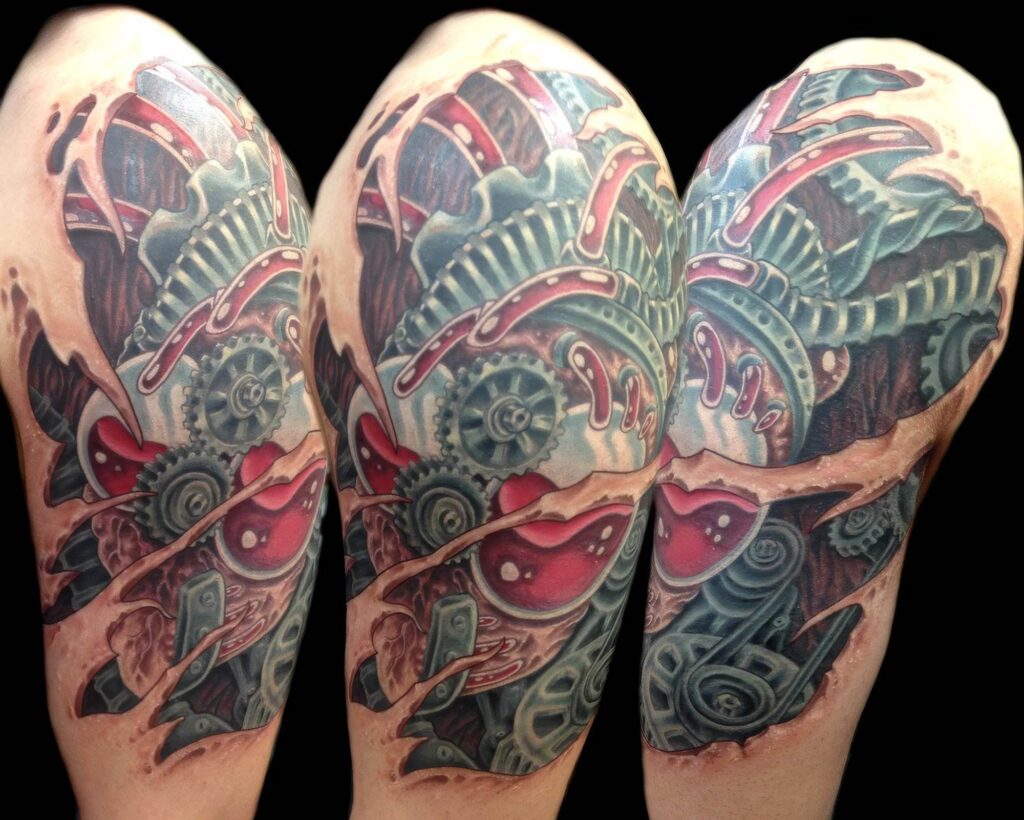 A detailed biomechanical tattoo showcasing gears, machinery, and red accents, inked on an upper arm.