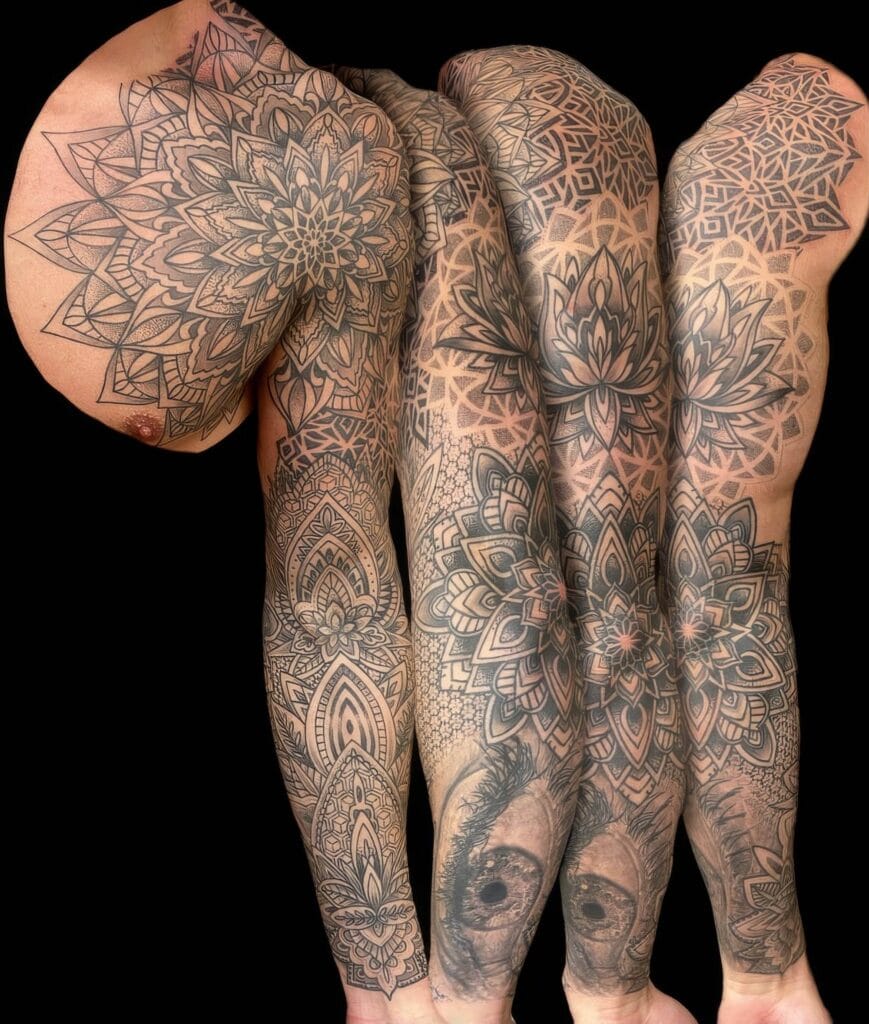 Close-up of four tattooed arms with intricate, black and gray geometric designs including mandalas and floral patterns.