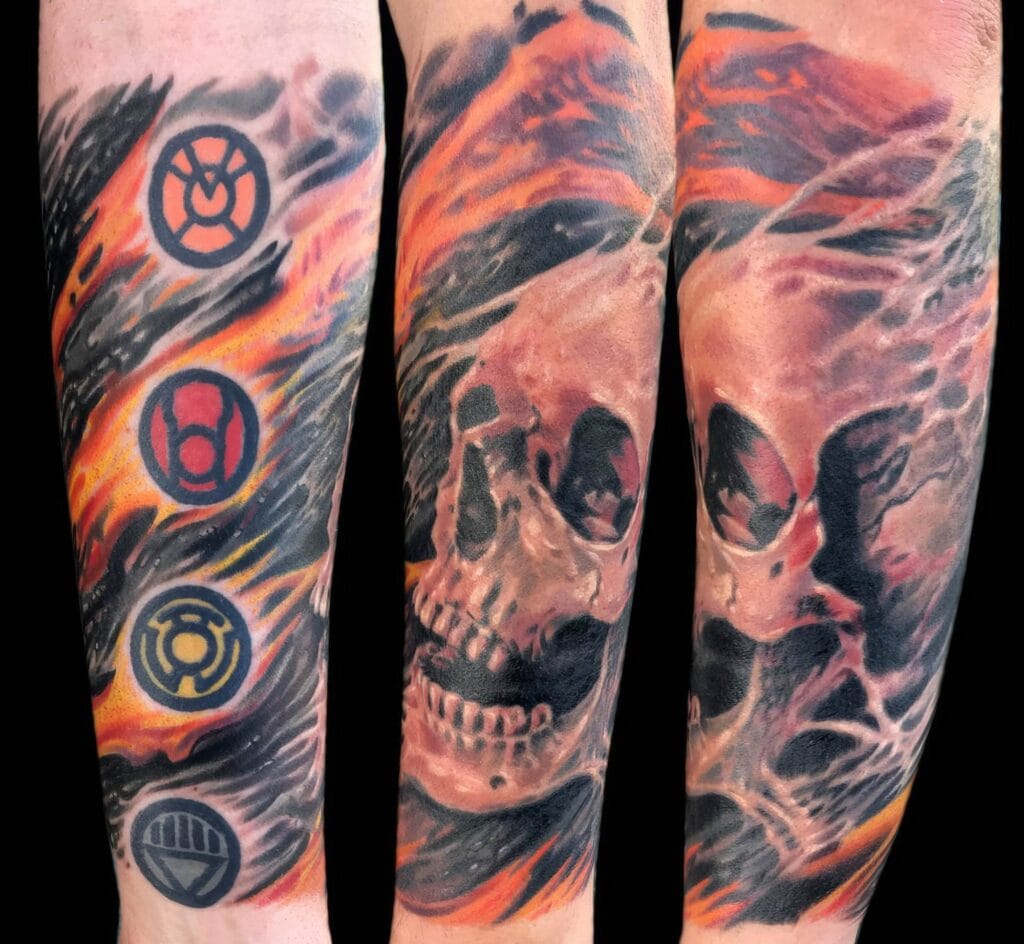A forearm tattoo featuring a skull enveloped in flames and four colored symbols to the left side.