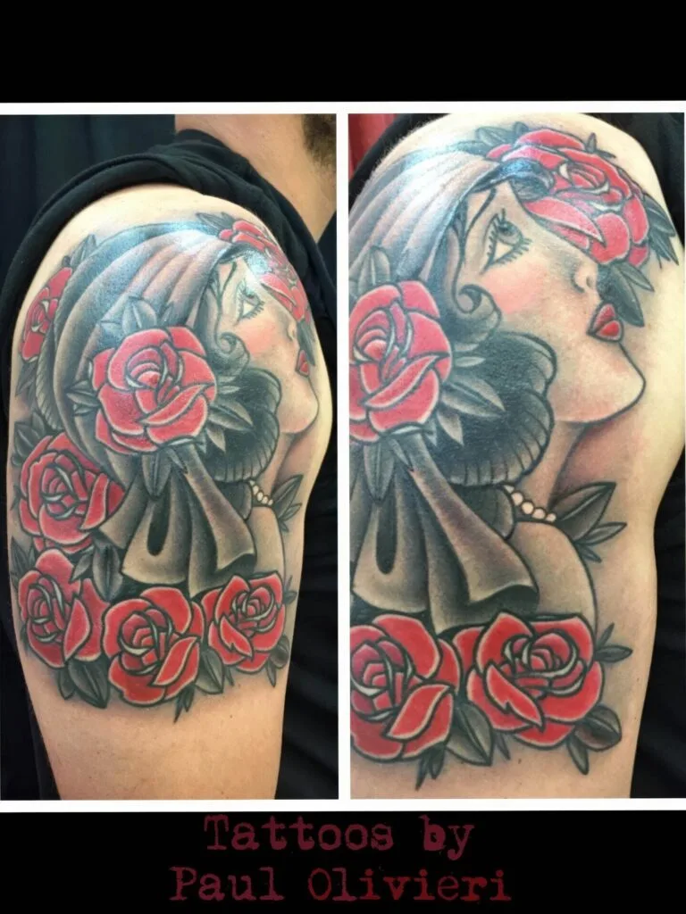 Tattoo of a woman with flowing hair and red roses on her shoulder.
