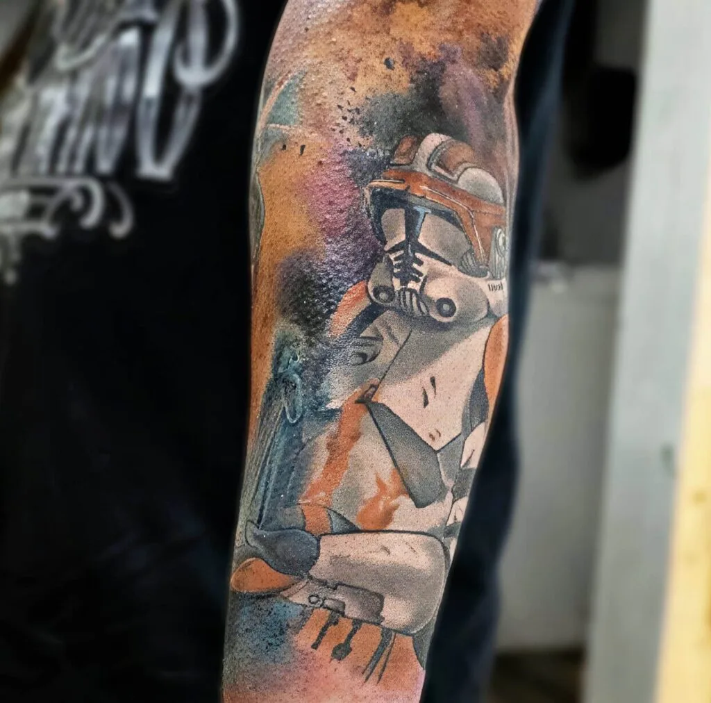 Colorful tattoo of a Star Wars stormtrooper helmet on a persons arm.