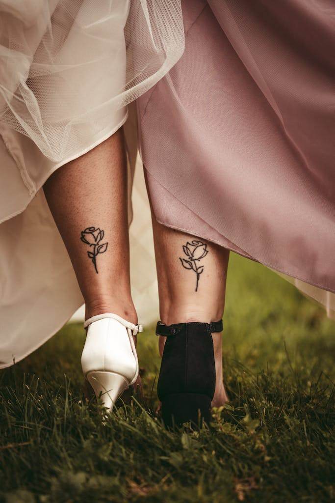 Close-up of Women Legs with Matching Rose Tattoos