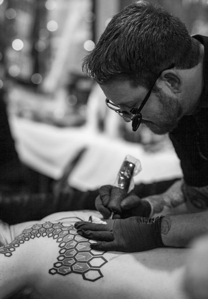 Monochrome Photo of Tattoo Artist tattooing a Client