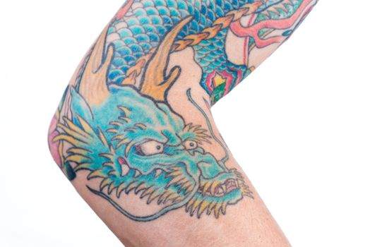 Colorful dragon tattoo on a person's arm, featuring blue scales, orange horns, and intricate details.