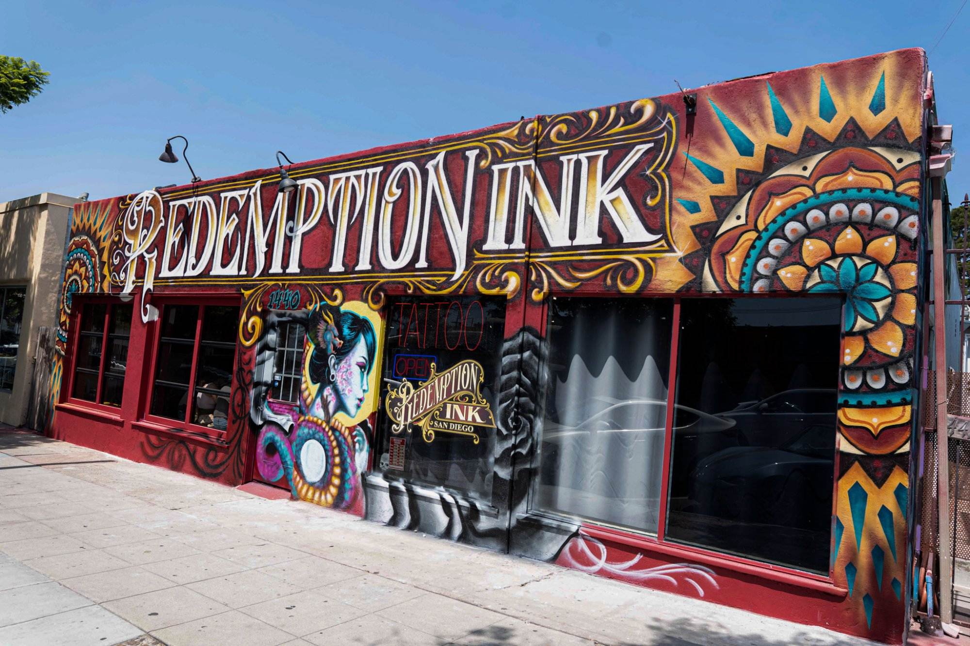 A colorful tattoo shop exterior with bold, artistic graffiti and the name "Redemption Ink" prominently displayed.