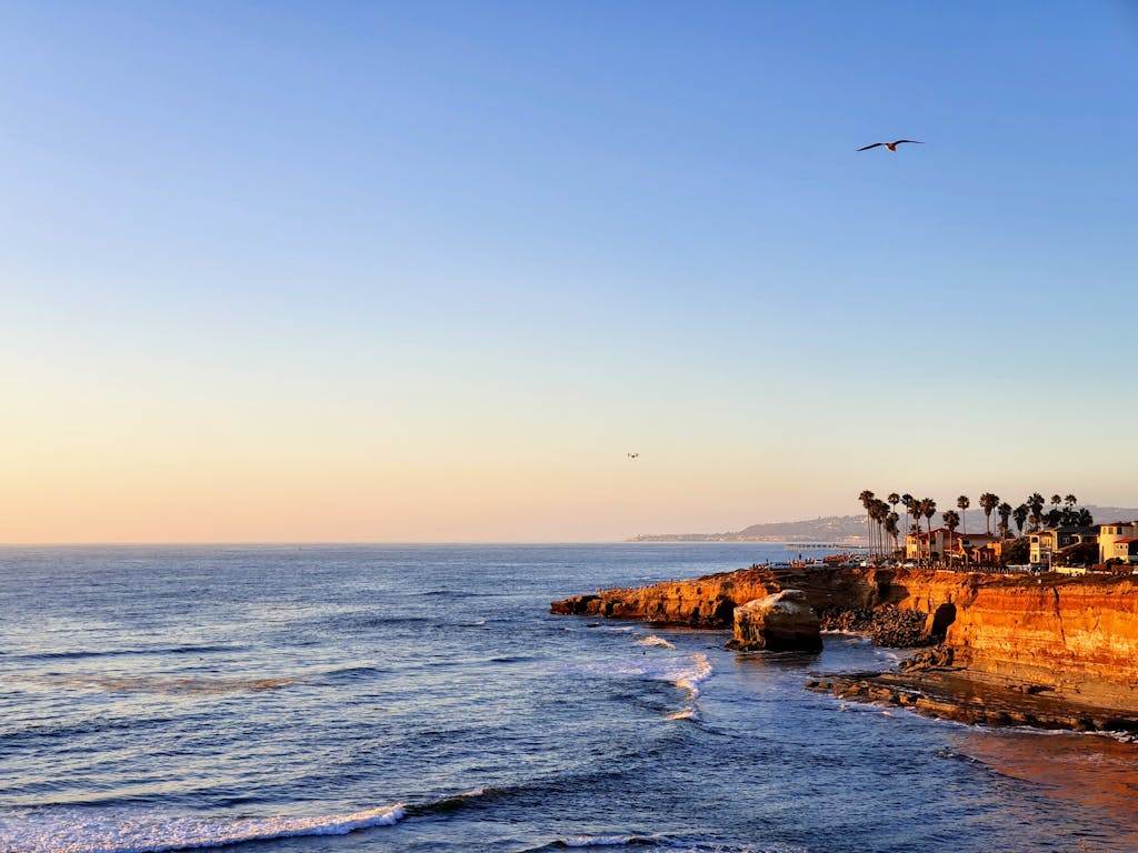 Breathtaking view of the San Diego coast at sunset, featuring cliffs and a tranquil ocean.