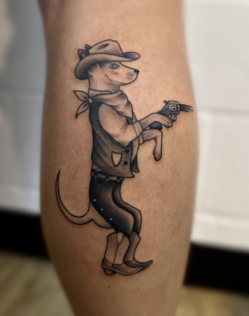 Anthropomorphic dog dressed as a cowboy, holding a revolver, with a tail visible.
