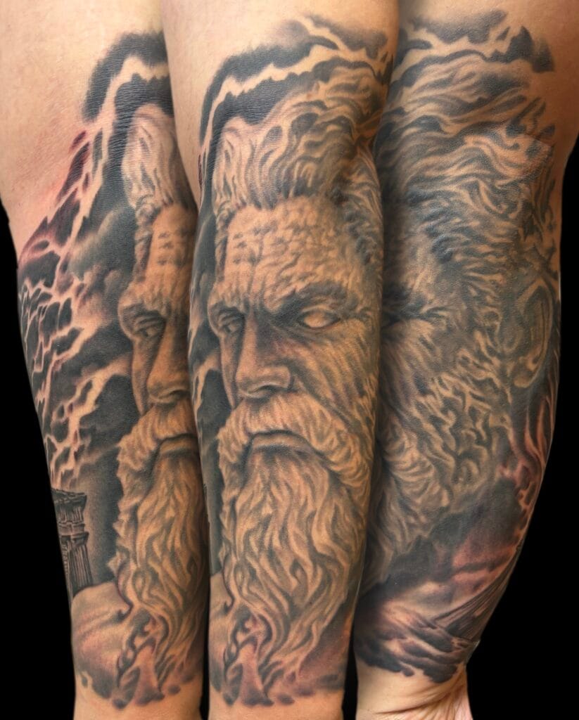 Tattoo of a bearded mans face with flowing hair and stormy clouds on arm.