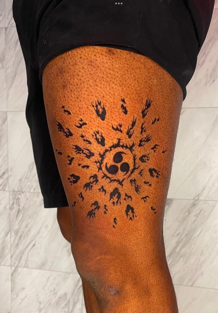 Black sun and moon design with flames and abstract shapes on a persons thigh.