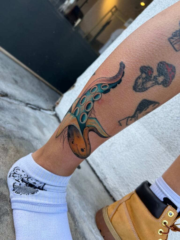 Colorful octopus tattoo on ankle, with white sock and tan boot.