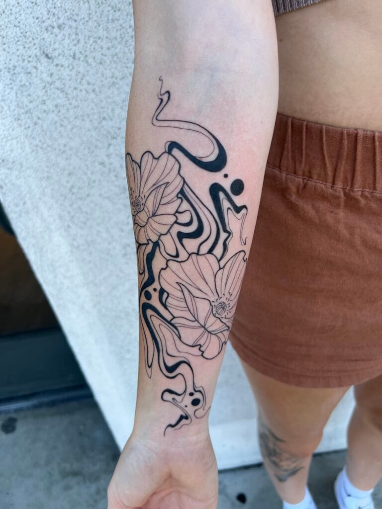 Black and pink floral tattoo with abstract lines on persons forearm.